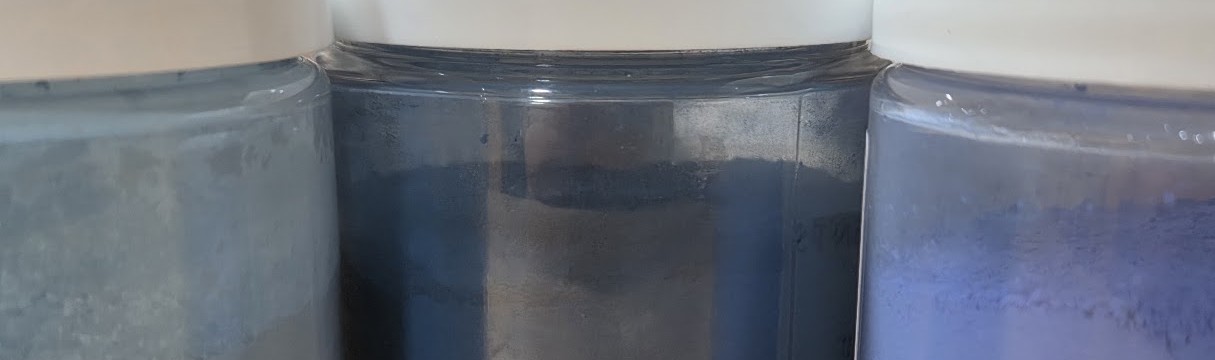 Various shades of blue pigment in clear jars with white lids.